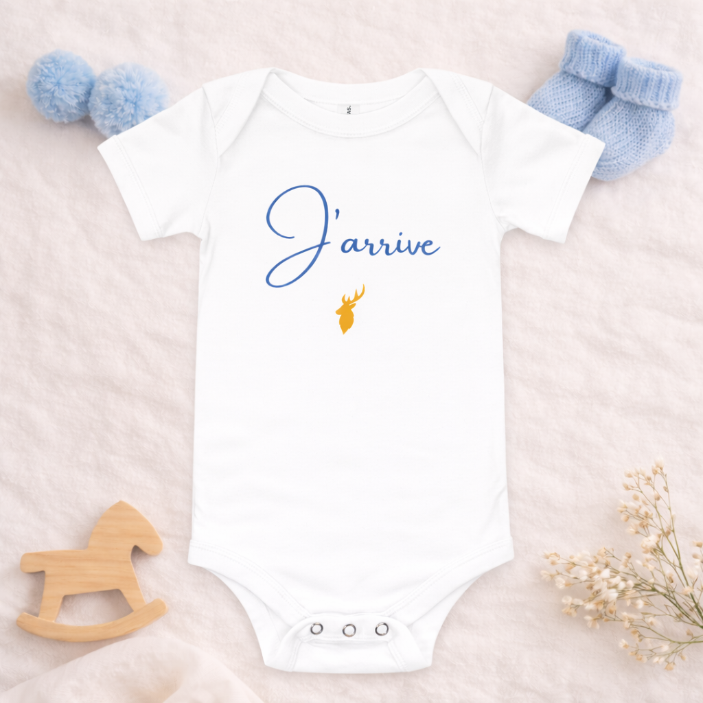 Body bébé “J’arrive” bleu posé en scène pour annoncer l’arrivée d’un petit garçon